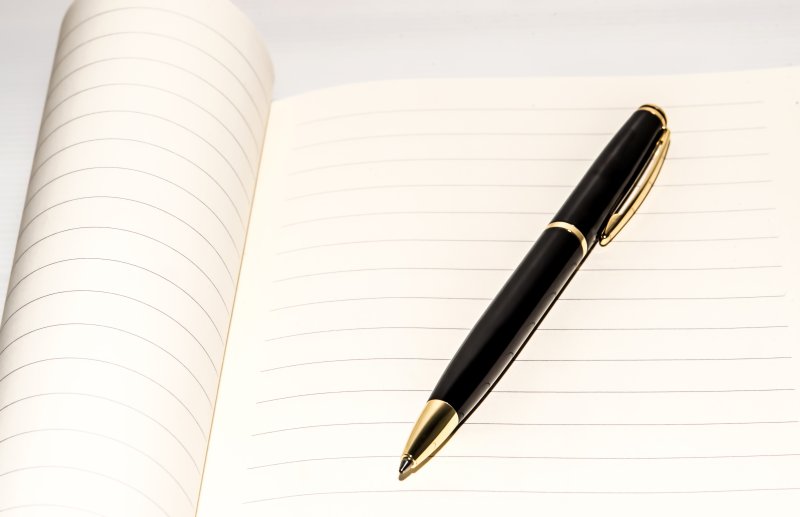 Ручка с бумагой на белом фоне