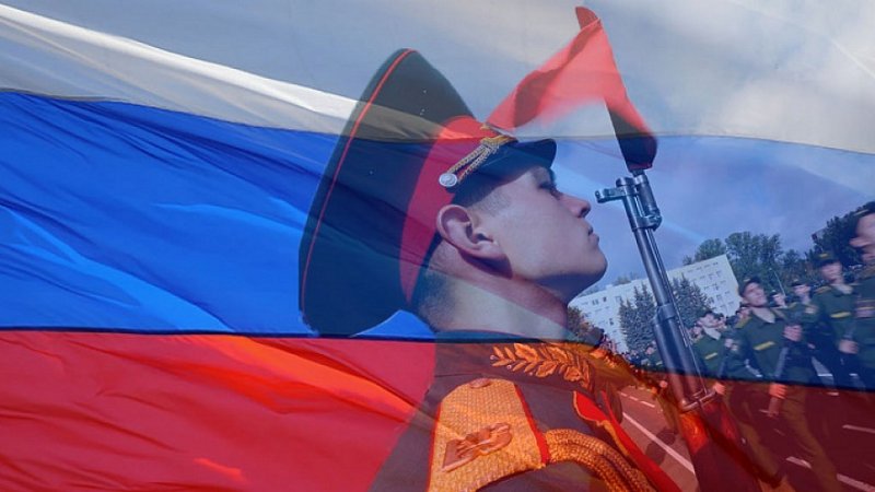Русский солдат на фоне флага