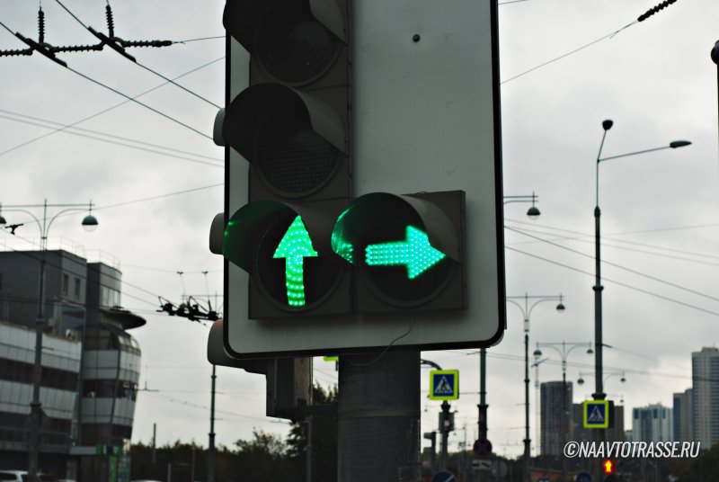 Зеленая стрелка на белом фоне на светофоре